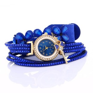 Key and Flowers Bracelet Watch Women This watch has all the best elements of the past, present and future. The modern, easy to read watch features a key hanging off the side and a attached flower design bracelet. You can tell time in an easy and efficient manner with this easy to read watch.